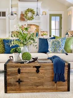 a living room filled with lots of furniture and flowers on top of a wooden trunk