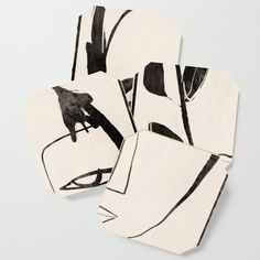 three coasters with black and white designs on them, one has a cat sitting on a chair