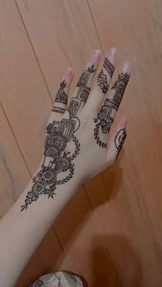 a woman's hand with henna tattoos on it