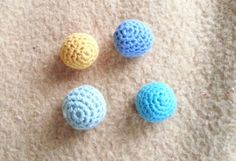 three crocheted balls sitting on top of a carpet