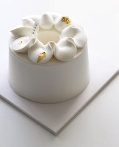 there is a white cake with gold decorations on it