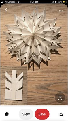 an origami snowflake on a wooden table with the text view save below