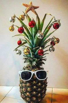 a pineapple decorated with christmas ornaments and sunglasses