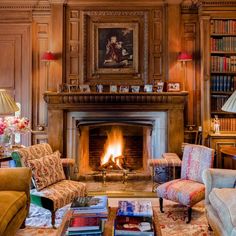 a living room filled with furniture and a fire place in the middle of a fireplace