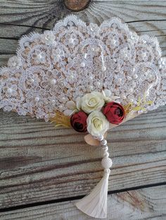 a bridal bouquet with white roses and red roses in it on a wooden table