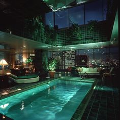 an indoor swimming pool in the middle of a room with lots of windows and furniture