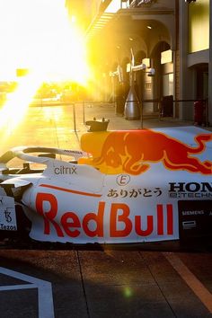 a red bull race car is parked on the street