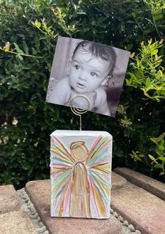 a small card with an angel on it and a photo attached to the front of it