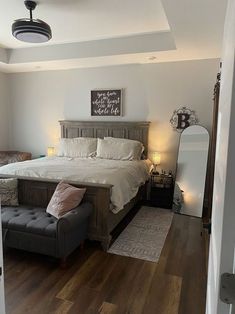 a bedroom with a large bed and wooden floors