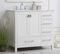 a white bathroom vanity with two sinks and a large mirror above the sink, next to a potted plant