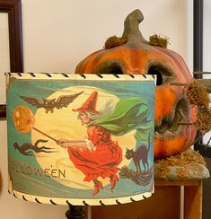 a lamp that is sitting on top of a wooden table next to some pumpkins