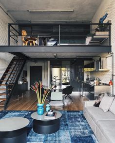 a living room filled with furniture and a stair case in the middle of the room