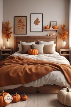 a bedroom with pumpkins on the floor and pictures on the wall above the bed