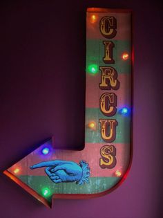 a neon sign that says circus with an arrow pointing up to it's right