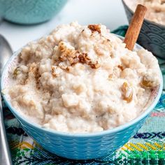 a blue bowl filled with oatmeal and topped with cinnamon