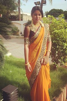 a woman in an orange and gold sari