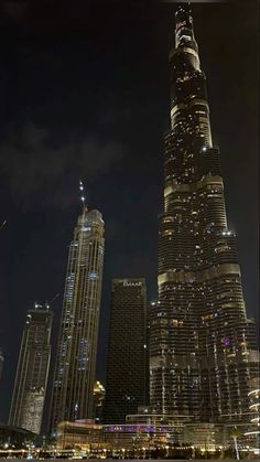 the burj building is lit up at night with lights on it's sides