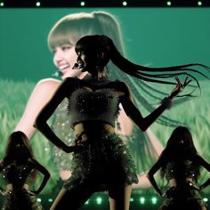 a woman with long hair standing in front of a group of other women on stage