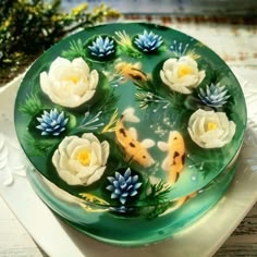 there is a cake decorated with koi fish and water lilies on the plate