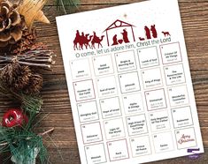 a calendar with the birth of jesus on it next to pine cones and christmas decorations