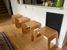 three wooden chairs sitting next to each other on top of a hard wood floored floor