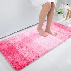 a woman standing on top of a pink rug in front of a white wall and floor