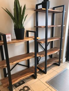 the shelves are made out of wood and have black metal brackets on each shelf, along with a potted plant