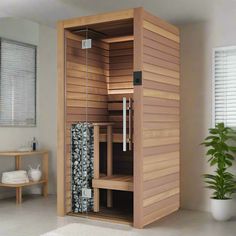 a large sauna in the middle of a room with a potted plant next to it