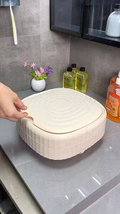 a person cutting up food on top of a counter in a room with gray walls