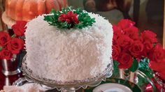 a white cake sitting on top of a table covered in frosting and poinsettis