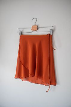 Ready for Ballet Class? Our classic, pumpkin spice orange -colored wrap ballet skirt is exactly made for that! This ballet dress is handmade with a stretchy black nylon waist tie for a comfortable experience. Crafted 100% out of polyester chiffon with a right above the knee design for a vintage look. ✷ Perfect for Recital ✷ This orange ballet dress is the perfect choice for a vintage/classy-style recital. A conservative style with a right above the knee design for a formal performance. Not only Ballet Class Outfit, Conservative Style, Short Wrap Skirt, Long Wrap Skirt, Conservative Fashion, Orange Chiffon, Ballet Clothes, Orange Skirt, Ballet Class