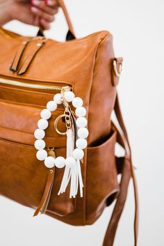 meet our customer-favorite ivy keychains’s funky younger sister - the sage wooden keychain. these bold bracelet keychains are just like our bestselling ivy’s, but with the addition of brightly colored beads and tassels. the sage comes in 7 colors ranging from neutral to neon, so there’s one for everyone! White Jewelry With Lobster Clasp For Everyday Use, White Wristlet With Key Leash For Everyday Use, Trendy White Wristlet With Keychain, Trendy White Keychain For Gifts, White Beaded Jewelry For Everyday Use, White Beaded Everyday Jewelry, Trendy White Wristlet, White Bag Charm Keychain For Everyday Use, Adjustable White Beaded Bracelet For Everyday