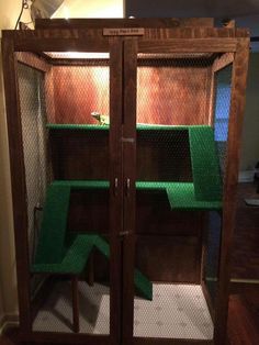 an indoor rabbit house with green grass inside and two doors open to the other side