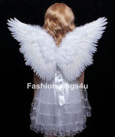 an angel with white wings is standing in front of a black background and has her back turned to the camera