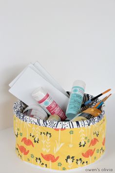 a close up of a container on a table with scissors and other items in it