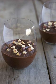 two glasses filled with chocolate pudding and nuts