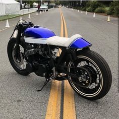 a blue and white motorcycle is parked on the street