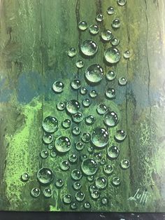 a painting with water drops on it and green paint in the background, as well as an image of a tree