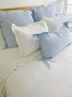 a bed with blue and white striped pillows