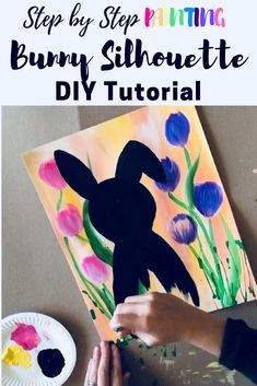 someone is painting a bunny silhouette on a paper plate with crayons and watercolors