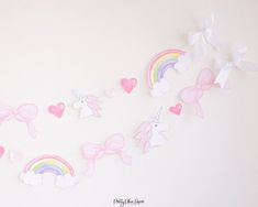 the wall is decorated with pastel pink and white bows, hearts, and unicorns