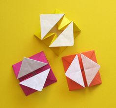 three origami pieces on a yellow background