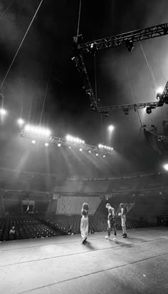 some people are playing basketball in an empty stadium with lights on the bleachers