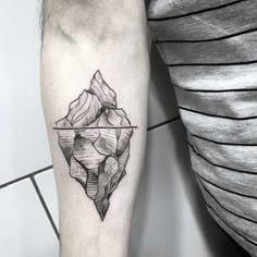 a black and white photo of an iceberg tattoo on the left forearm, with a line work design