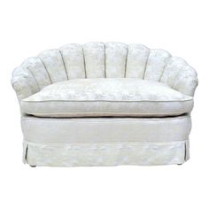 an upholstered chair with white fabric on the back and foot rests against a white background