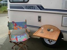 a chair and table sitting in front of a camper