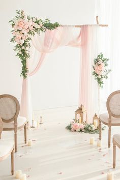 the wedding ceremony is decorated with pink flowers and greenery