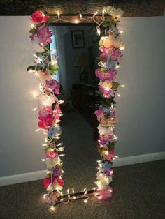 a mirror decorated with lights and flowers in the shape of a letter n on carpeted floor