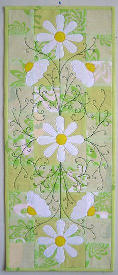 a wall hanging with white flowers on it