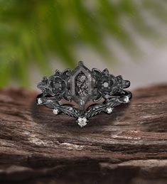 a close up of a ring on top of a piece of wood with leaves and flowers